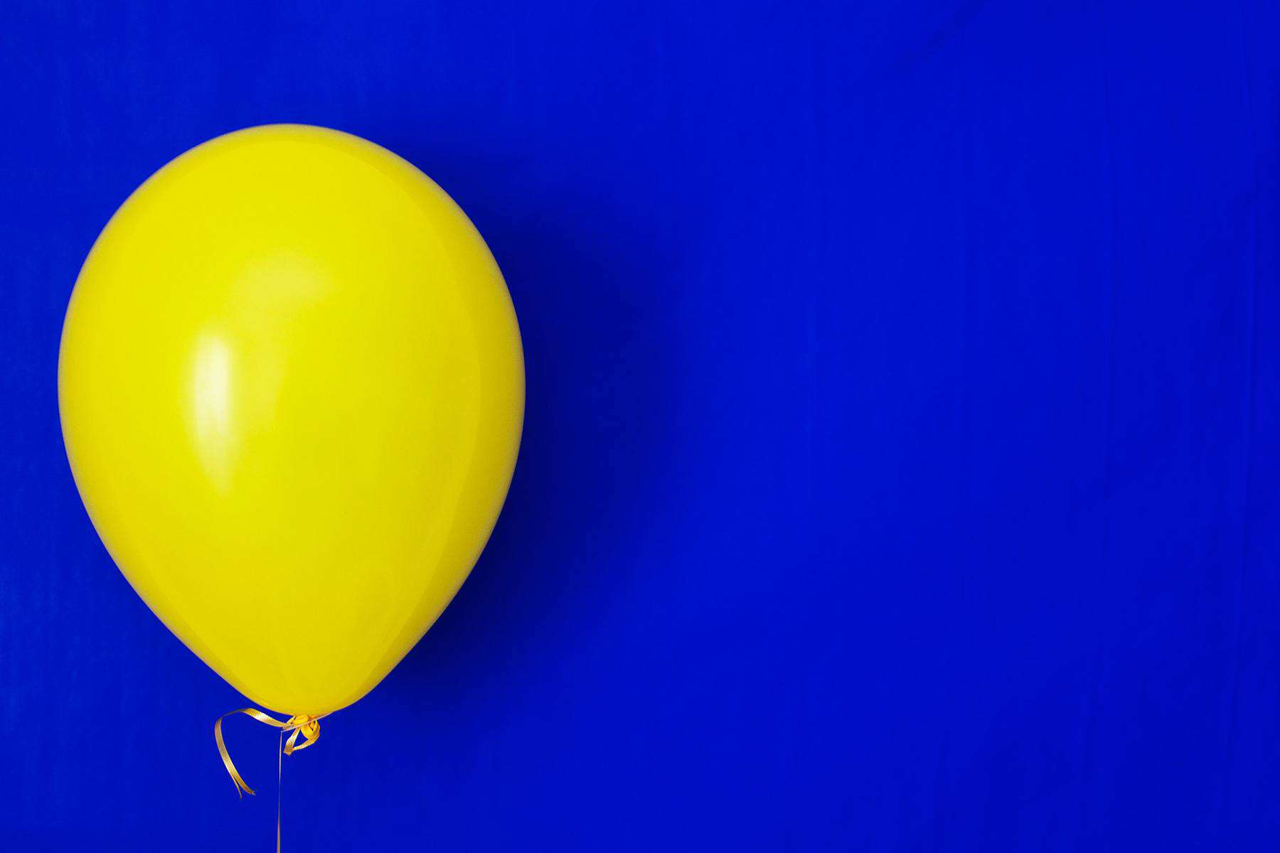 Yellow balloon on blue background 